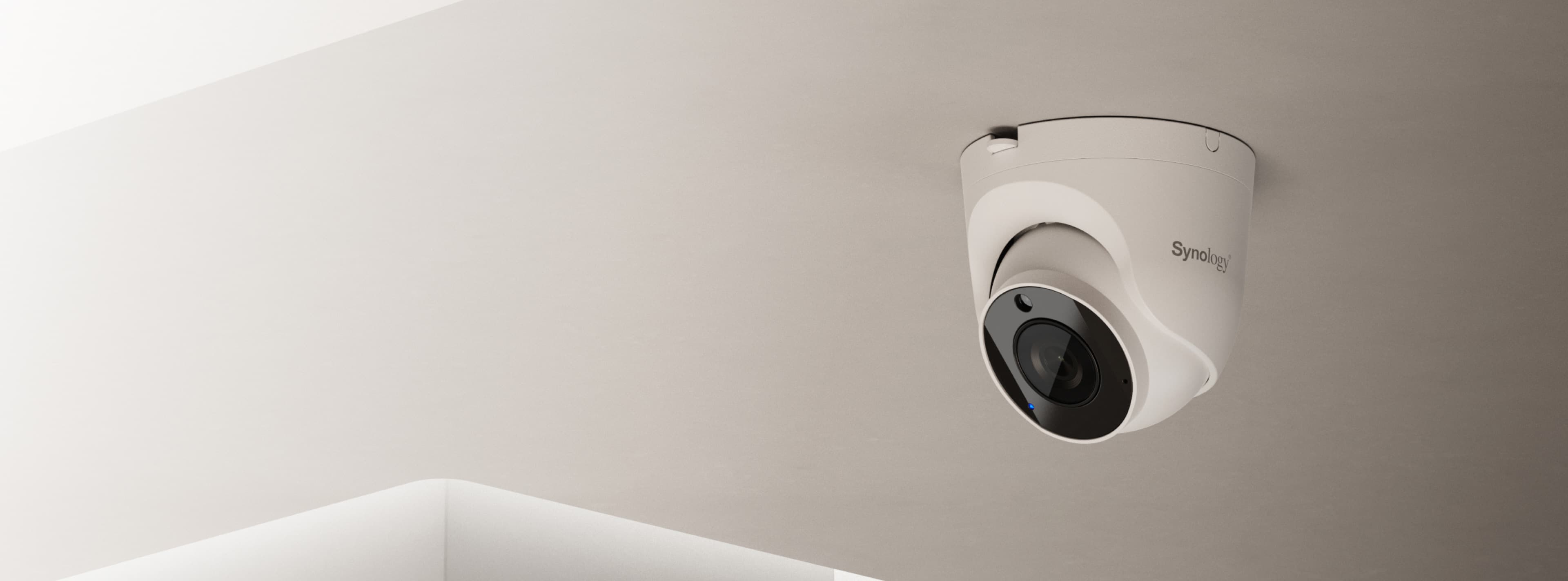 Synology TC510 turret camera mounted on a ceiling soffit - manufacturer in-situ image; Synology publishes this as the banner for its TC500-series turrets, of which the TC510 is one