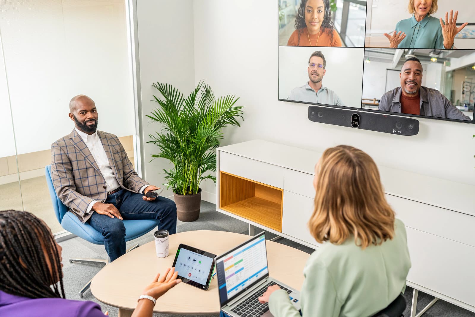 Poly Studio X70 in use above a meeting-room display — Poly Studio X70 lifestyle image; the display and room furniture are not included