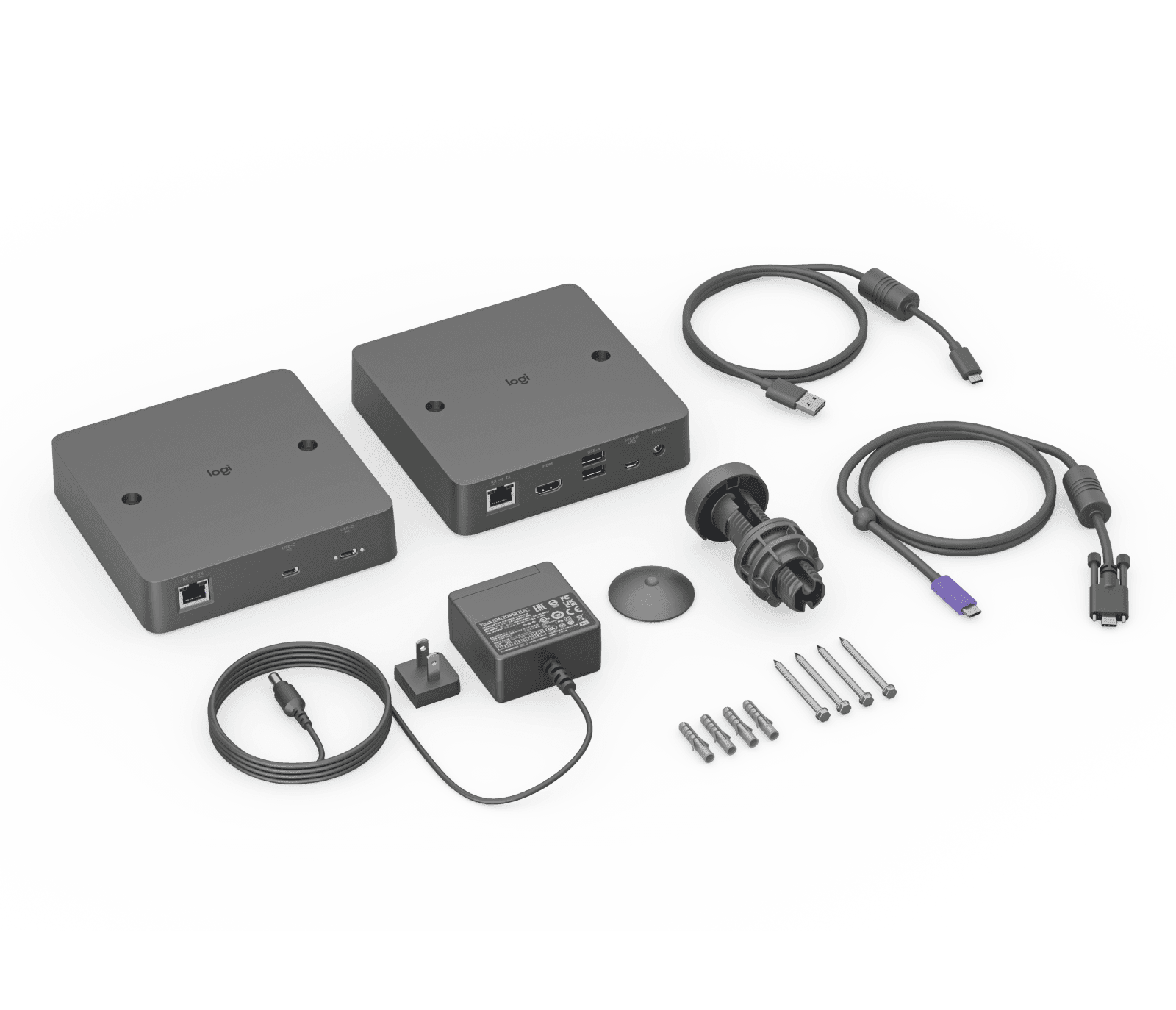 Everything supplied in the Logitech Extend kit laid out in graphite: the two transceiver boxes, power supply with UK plug, DC lead, table grommet, USB cables and mounting screws